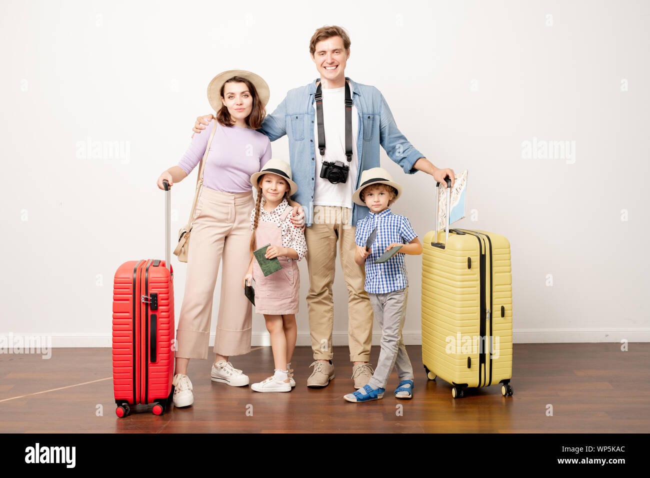 Studio shot del giovane famiglia di quattro in informale avrà viaggio Foto Stock