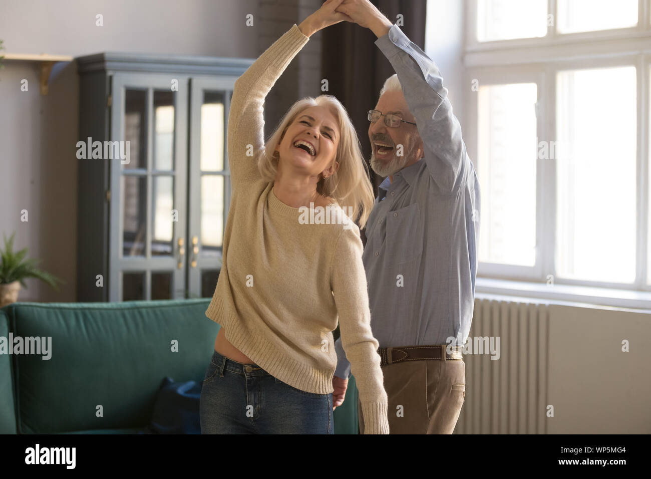Overjoyed coppia senior relax dancing at home Foto Stock