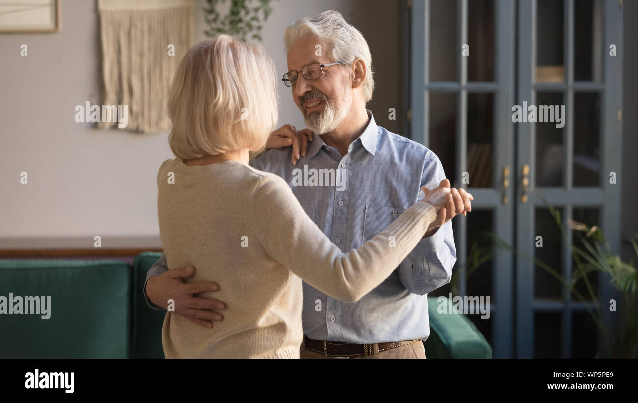 Coppia di anziani godono di tempo insieme a ballare a casa Foto Stock