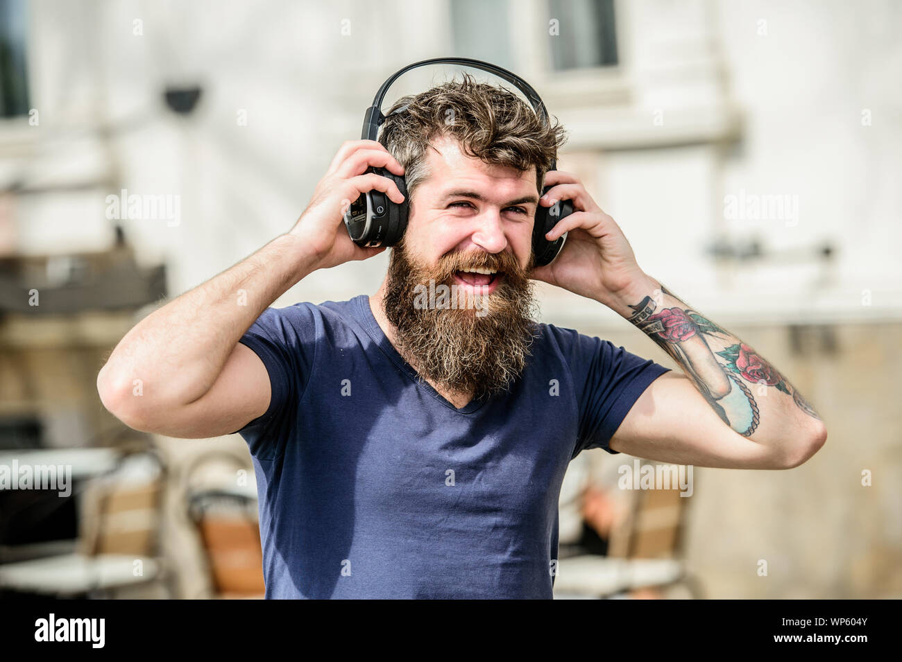 Musica per energico l'umore. Ritmo per camminare. Uomo Barbuto hipster  ascolto in cuffia la musica. Hipster godere di un suono di ottima canzone  in auricolari. Camminare con la musica. Ottima musica playlist