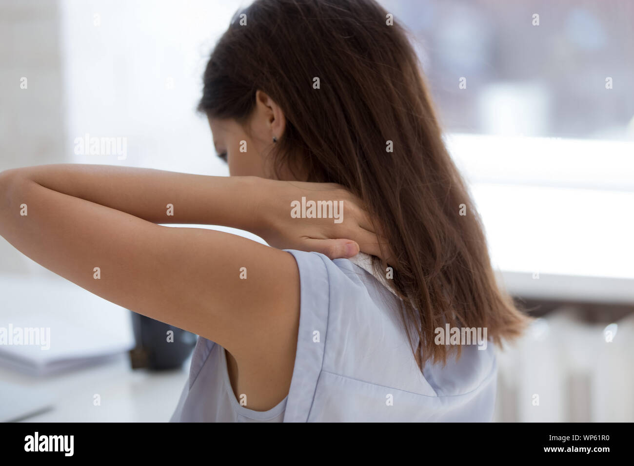 Stanco giovane donna il massaggio schiena soffre di dolore Foto Stock