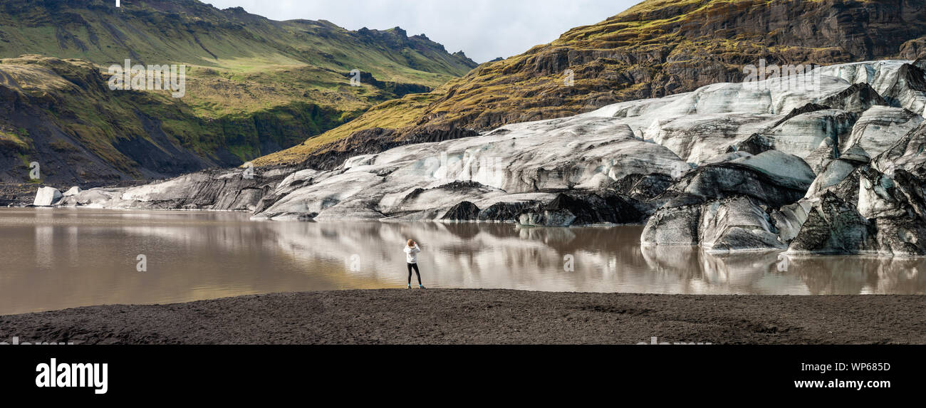 Ragazza di scattare una foto al ghiacciaio Solheimajökull, Islanda Foto Stock