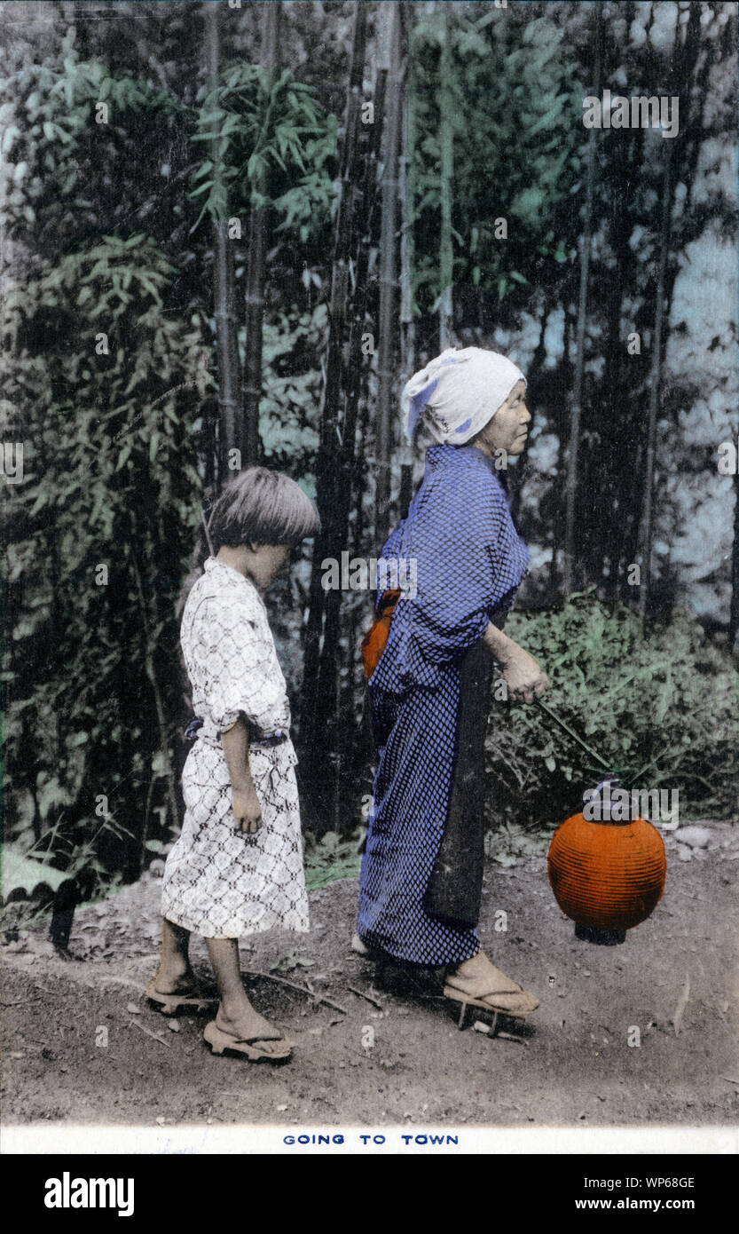 [ 1920s Giappone - agricoltore Donna e bambina ] - Una donna tenendo un chochin (lanterna di carta), e una giovane ragazza su una strada di campagna. Entrambi sono indossare uno yukata. Questa cartolina è da una serie sull agricoltura giapponese, chiamato Farmer vita in Giappone. Xx secolo cartolina vintage. Foto Stock