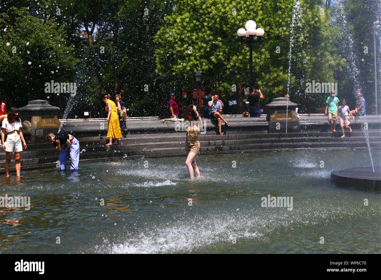 Le persone che si godono le calde giornate estive in Washington Square Park fontana in Manhattan su luglio 19th, 2019 a New York, Stati Uniti d'America. (Foto di Wojciech Migda) Foto Stock