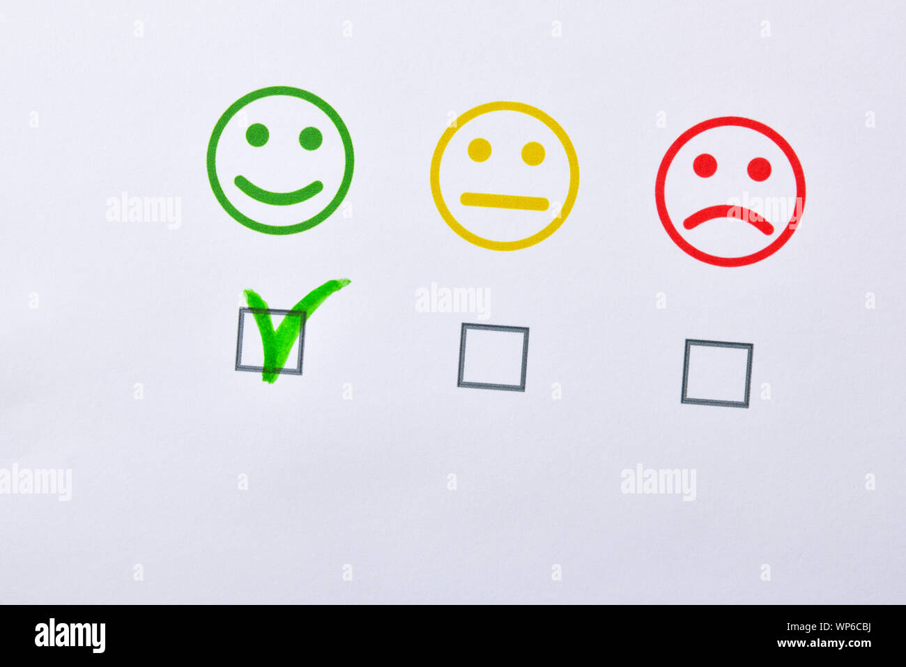 Valutazione della soddisfazione controllato su carta con la faccia di rappresentanza. Composizione orizzontale. Vista dall'alto. Foto Stock