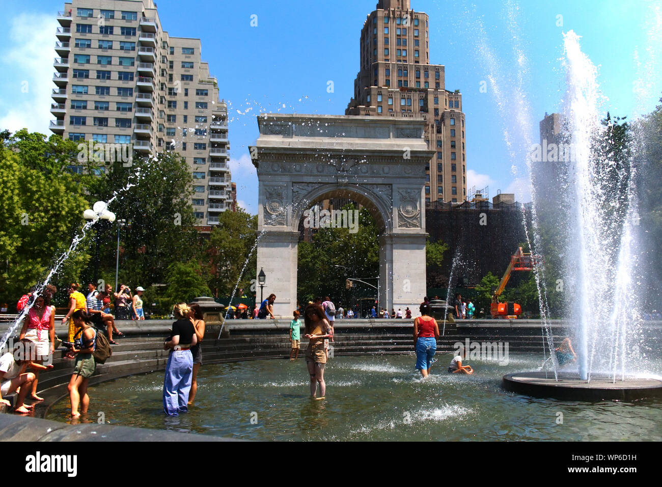 Le persone che si godono le calde giornate estive in Washington Square Park fontana in Manhattan su luglio 19th, 2019 a New York, Stati Uniti d'America. (Foto di Wojciech Migda) Foto Stock