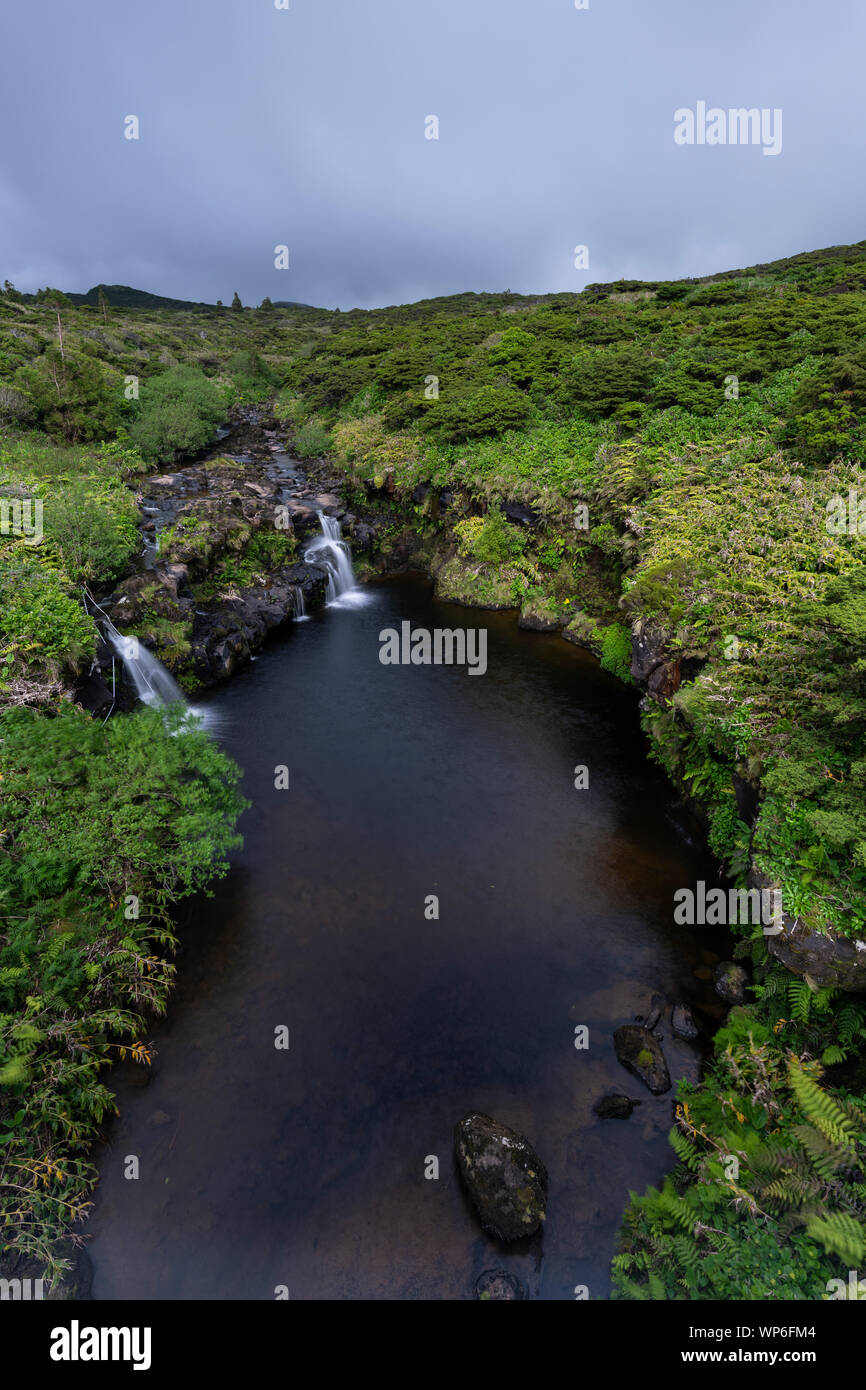 Paesaggio con ruscello e piccole cascate sulla sommità di Poço Ribeira do Ferreiro a Fajã Grande e Fajãzinha, Azzorre, Portogallo Foto Stock