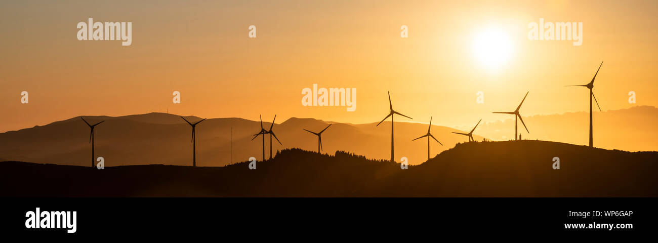 Un vento lontano con le turbine eoliche a Planalto dos Graminhais in un giallo tramonto poetico impostazione, che serve come una immagine perfetta per il verde rinnovabili sostenibili Foto Stock