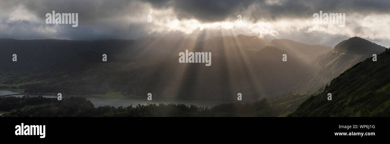 Un paesaggio fantastico con fasci di raggi di luce sulla Lagoa Verde (Lagoa das Sete Cidades), con il Pico da Cruz, iradouro da Boca do Inferno e Vista Foto Stock