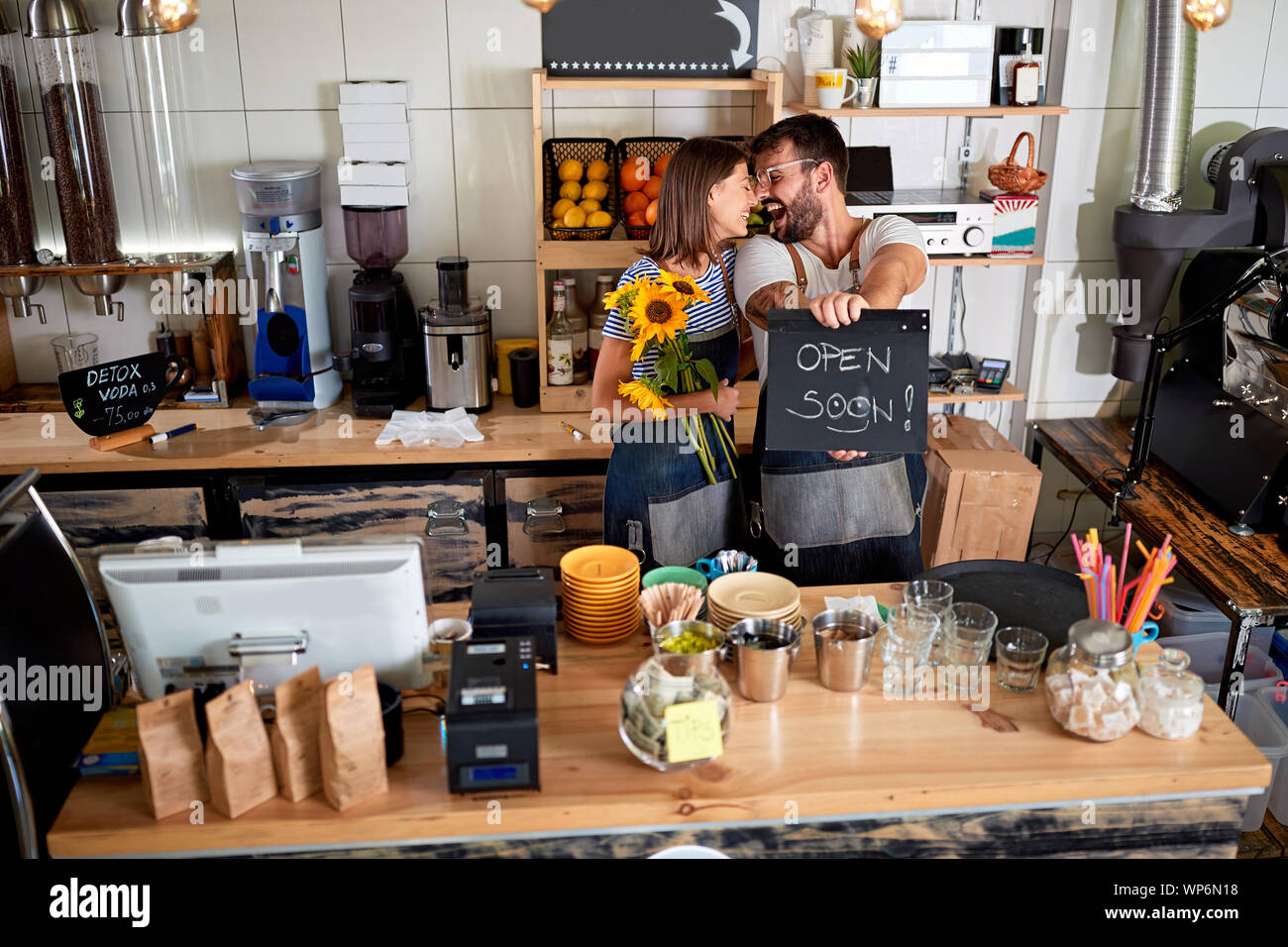 Il coffee bar è aperto - Happy uomo e donna proprietario con open firmare nel loro negozio cafe. Foto Stock