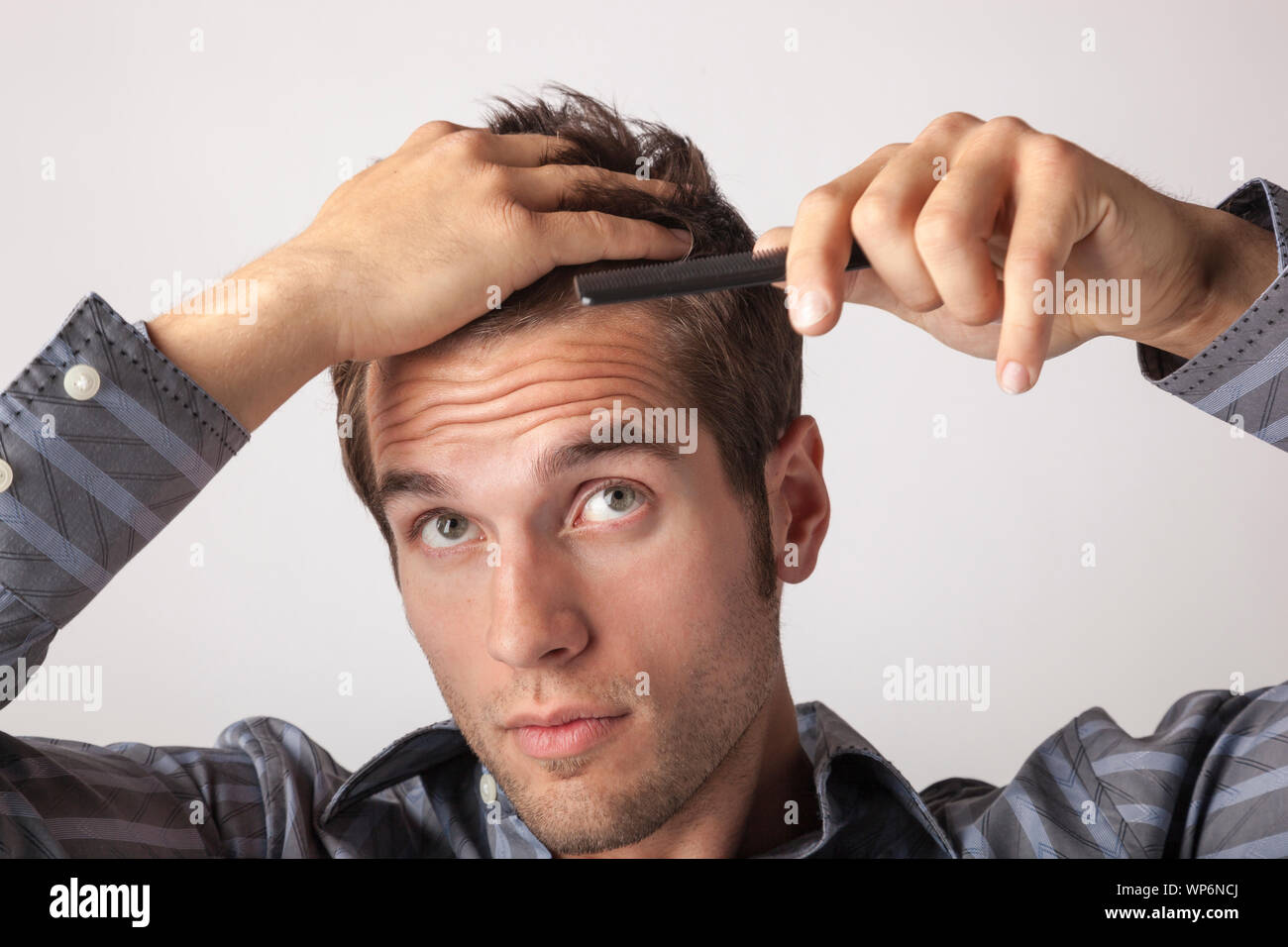 Giovane uomo pettinare i capelli. Uomini acconciature di toelettatura e cura personale. Foto Stock