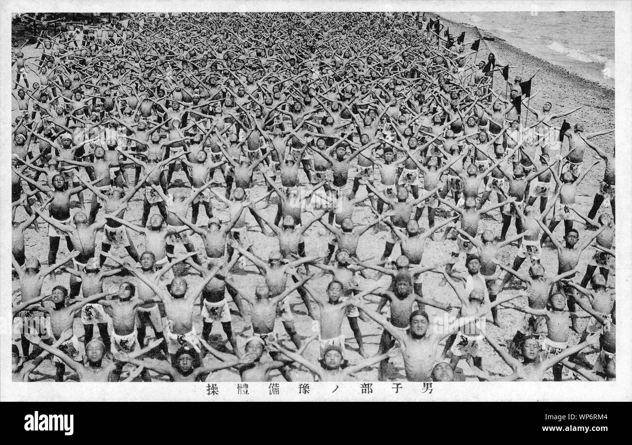 [ 1920s Giappone - esercizi ginnici da giovani ragazzi ] - Giovani studenti maschi fare esercizi ginnici su Suma Beach a Kobe, Hyogo in Giappone nel luglio 1927 (Showa 2). Esercizi di massa come questa erano molto popolari durante i primi Showa periodo (1926-1989). Xx secolo cartolina vintage. Foto Stock