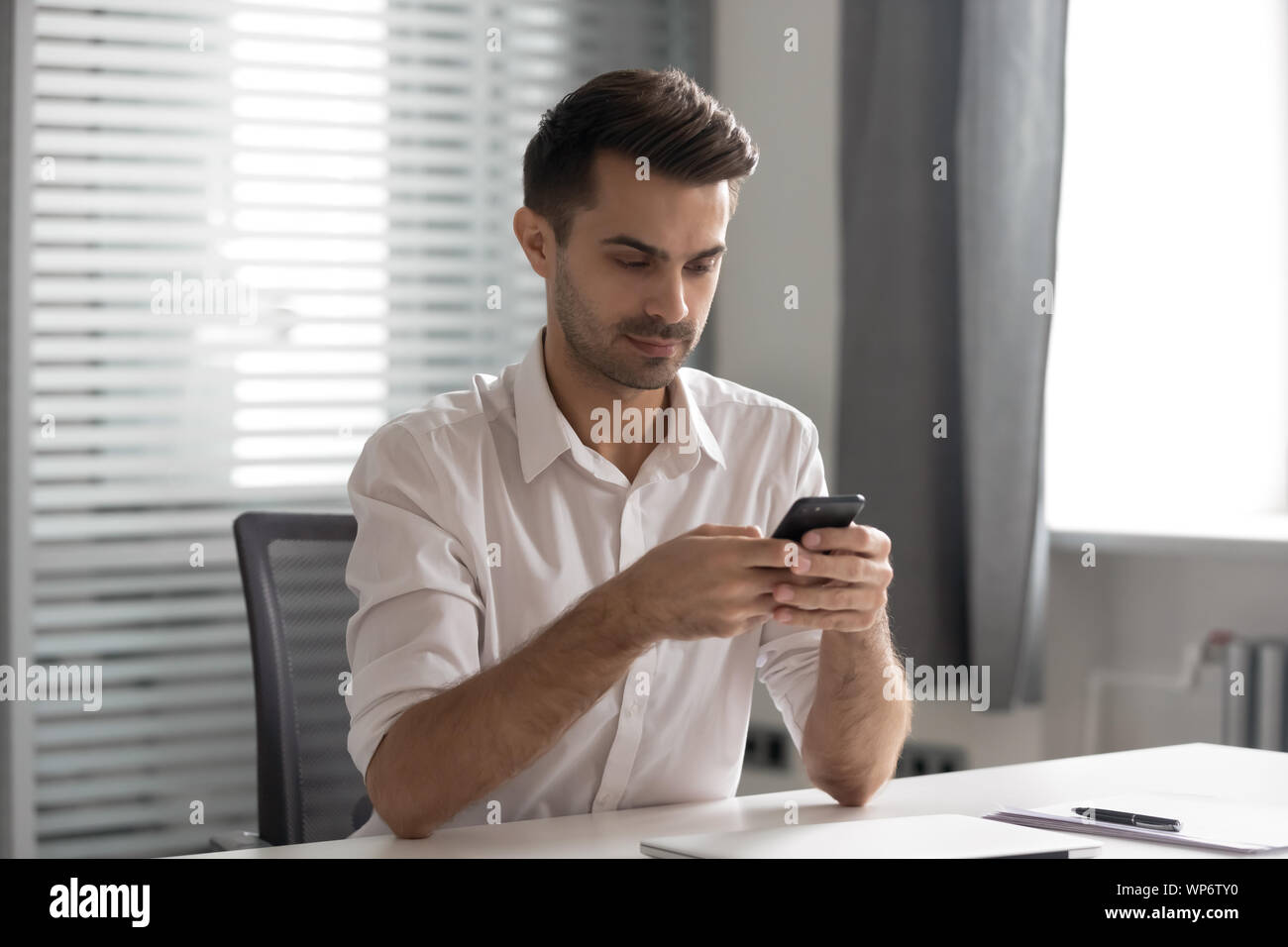 Grave giovane dirigente manager utilizzando società interna messenger application. Foto Stock
