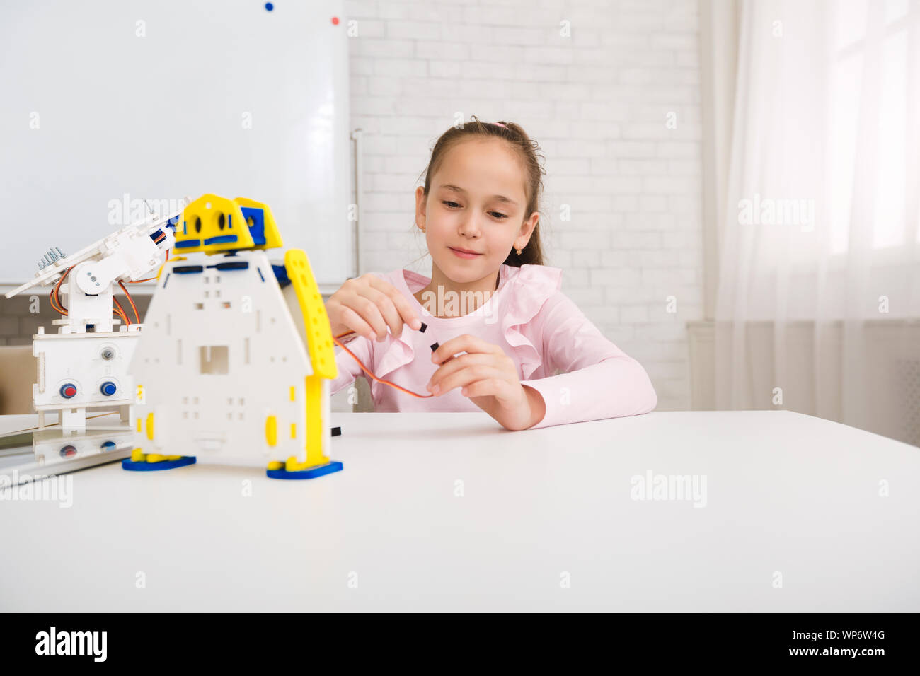 Ragazza robot programmazione, lavora con i fili in classe Foto Stock