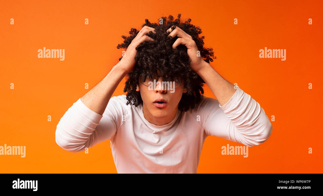 Scioccato emozionale uomo africano di straziare i suoi capelli nel gesto disperato Foto Stock