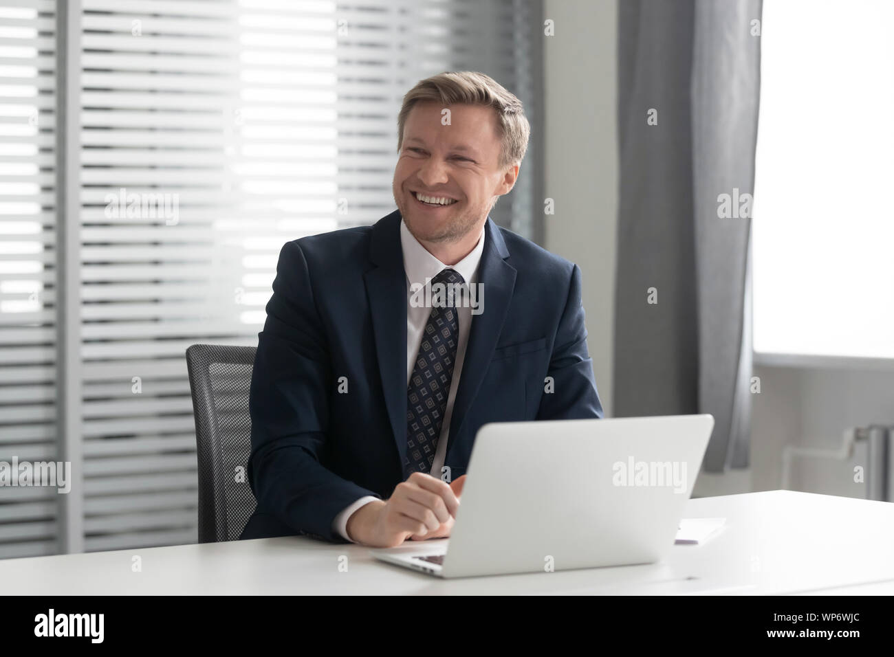 Happy businessman ridendo, ascolto per scherzo, divertirsi presso l'ufficio. Foto Stock