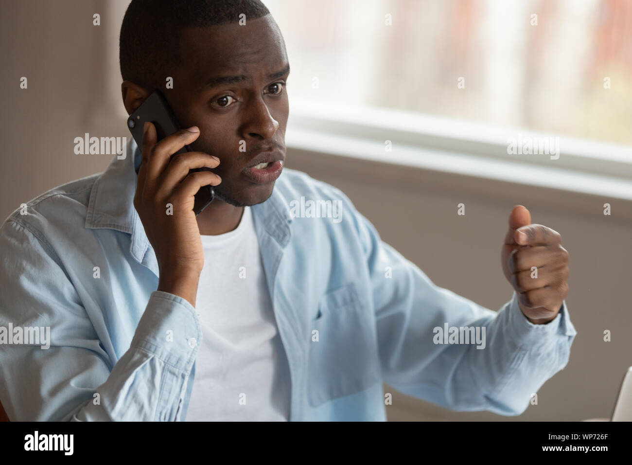 Insoddisfatto biracial man aventi sgradevole conversazione cellulare Foto Stock