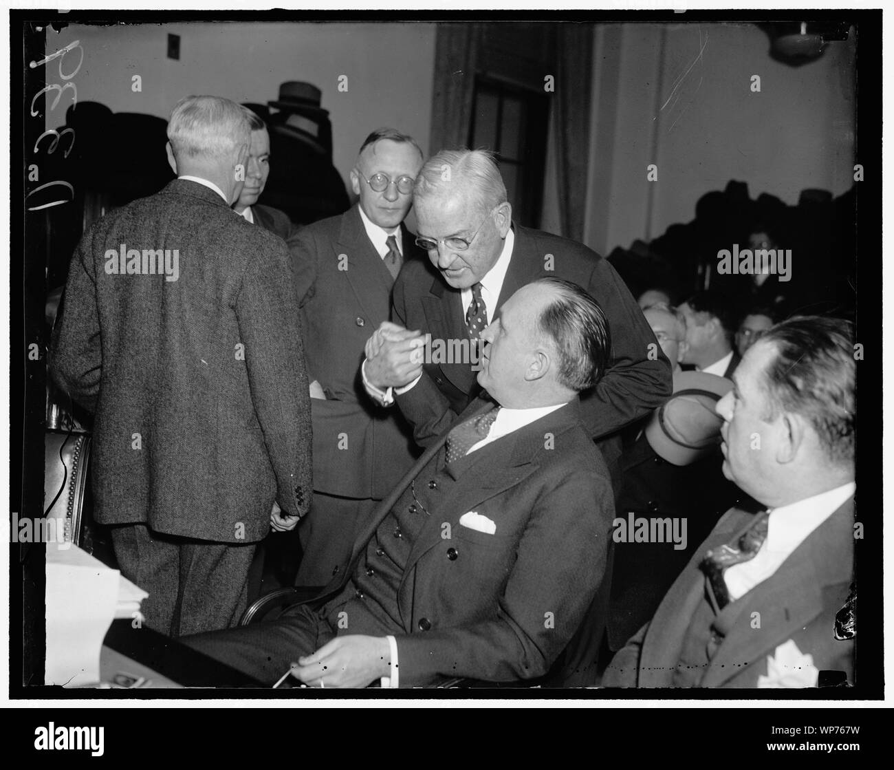Last-minute huddle. Washington, 8 dicembre. Harvey D. Gibson, (in piedi) Presidente dei costruttori Trust Company, passa in un last minute huddle con John P. Murphy, Direttore del Mid-America Corporation, prima del Senato Inchiesta sul finanziamento della ferrovia di oggi. Gibson ha testimoniato che la sua società avanzate per Mid-America Corporation $1,600,00 del $3,121,00 utilizzato per acquistare il furgone Swerigan titoli ad asta Foto Stock