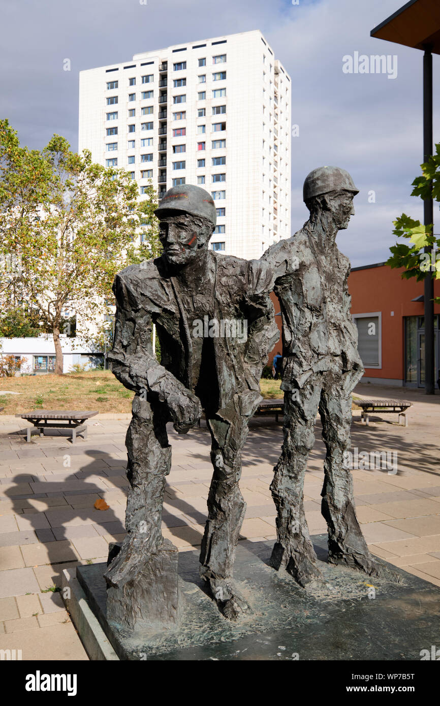 Statua di 'Monument al costruttore di Marzahn' da Karl Hillert davanti a uno dei modernisti socialista blocco di appartamenti della zona di Berlino Foto Stock