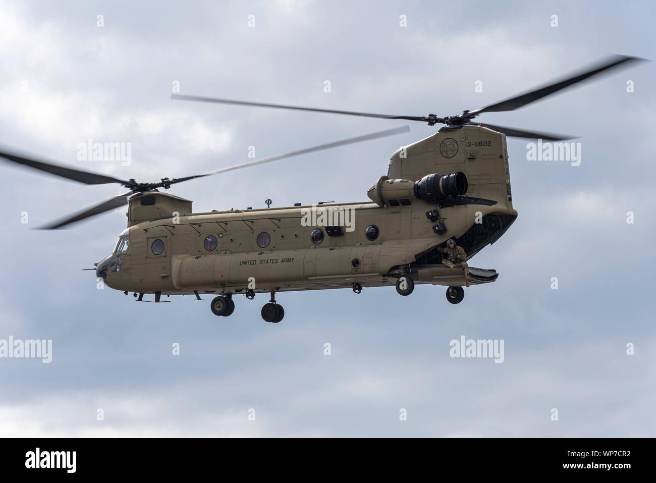 US Army Boeing CH-47F elicottero Chinook in atterraggio a difesa della sicurezza & Equipment International DSEI arms fair trade show, Excel, London, Regno Unito. Crewman Foto Stock