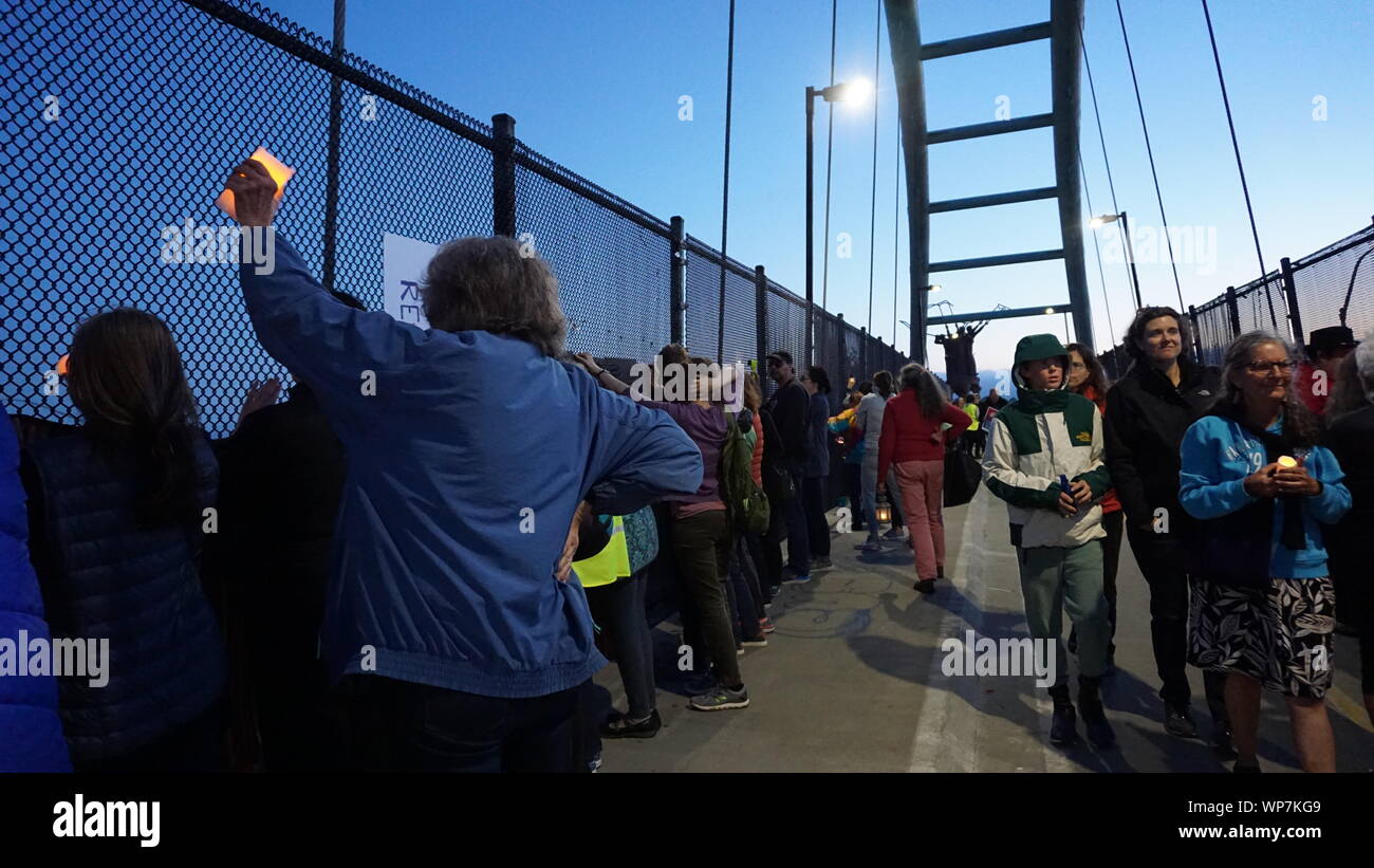 Luci per la veglia di Liberty per protestare contro di noi i campi di detenzione alla frontiera. I manifestanti in Berkeley ponte pedonale oltre l'autostrada 80 portando candele accese. Foto Stock