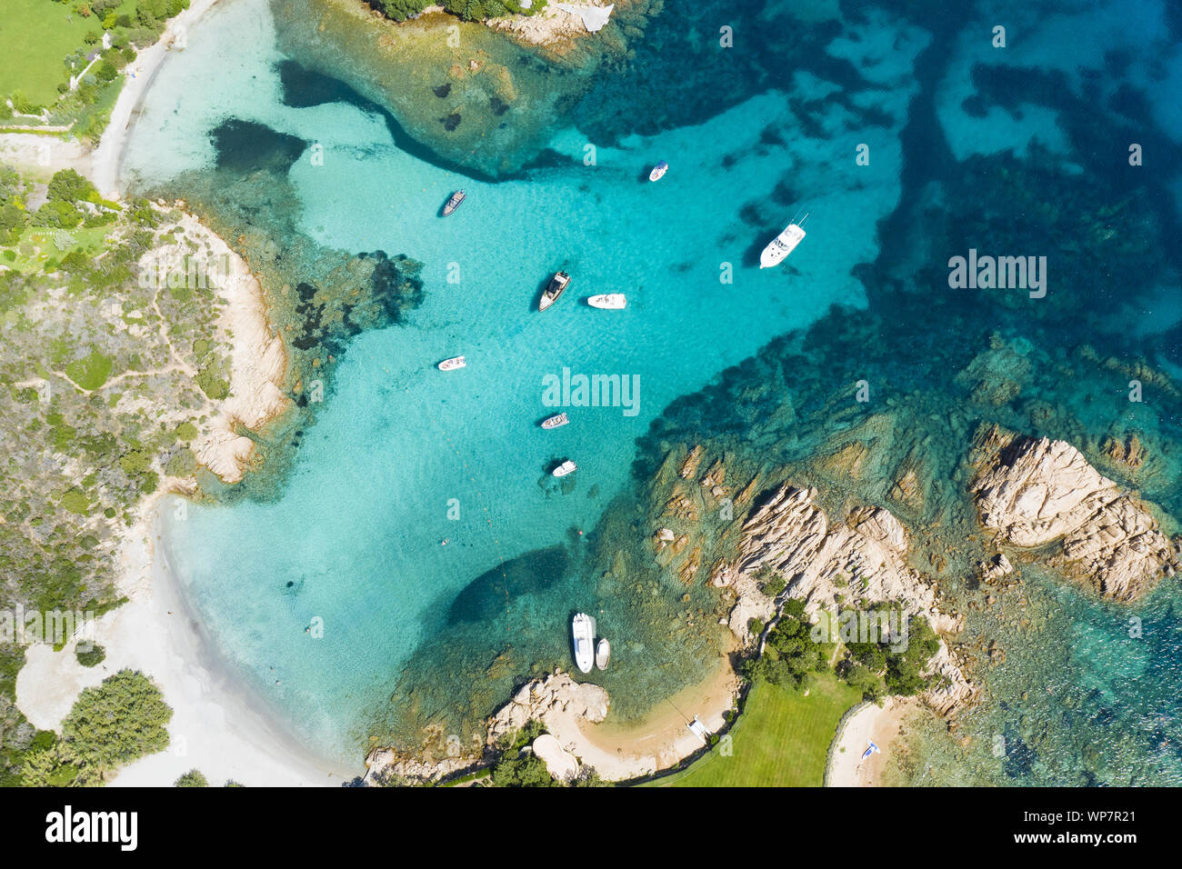 Vista da sopra, splendida vista aerea di alcune barche e yacht di lusso galleggiante su un acqua turchese. Parco nazionale Arcipelago di La Maddalena, in Sardegna. Foto Stock