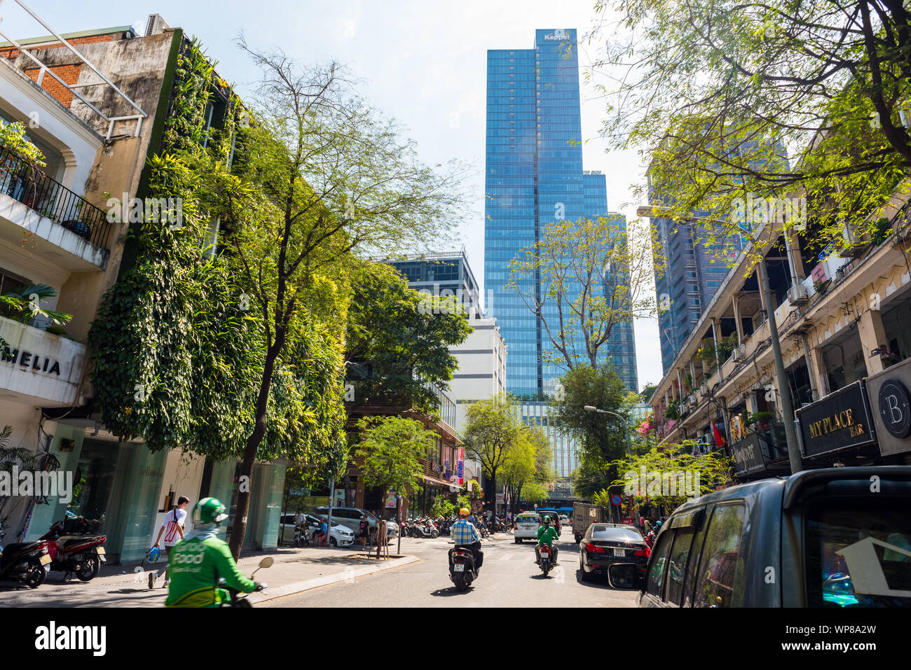 La città di Ho Chi Minh, Vietnam - 13 Aprile 2019: una strada del centro cittadino con una casa con un paesaggio verticale e una torre del centro di Saigon. Foto Stock