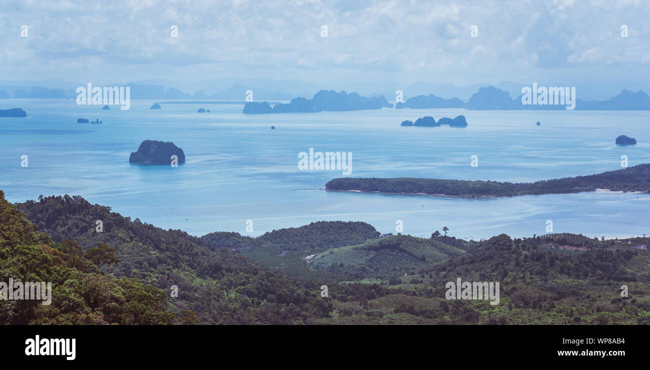 Splendido panorama tropicale della costa collinare e mare liscio spazio con numerose isole rocciose e isolotti sotto il cielo di ricci. Krabi, Thailandia Foto Stock