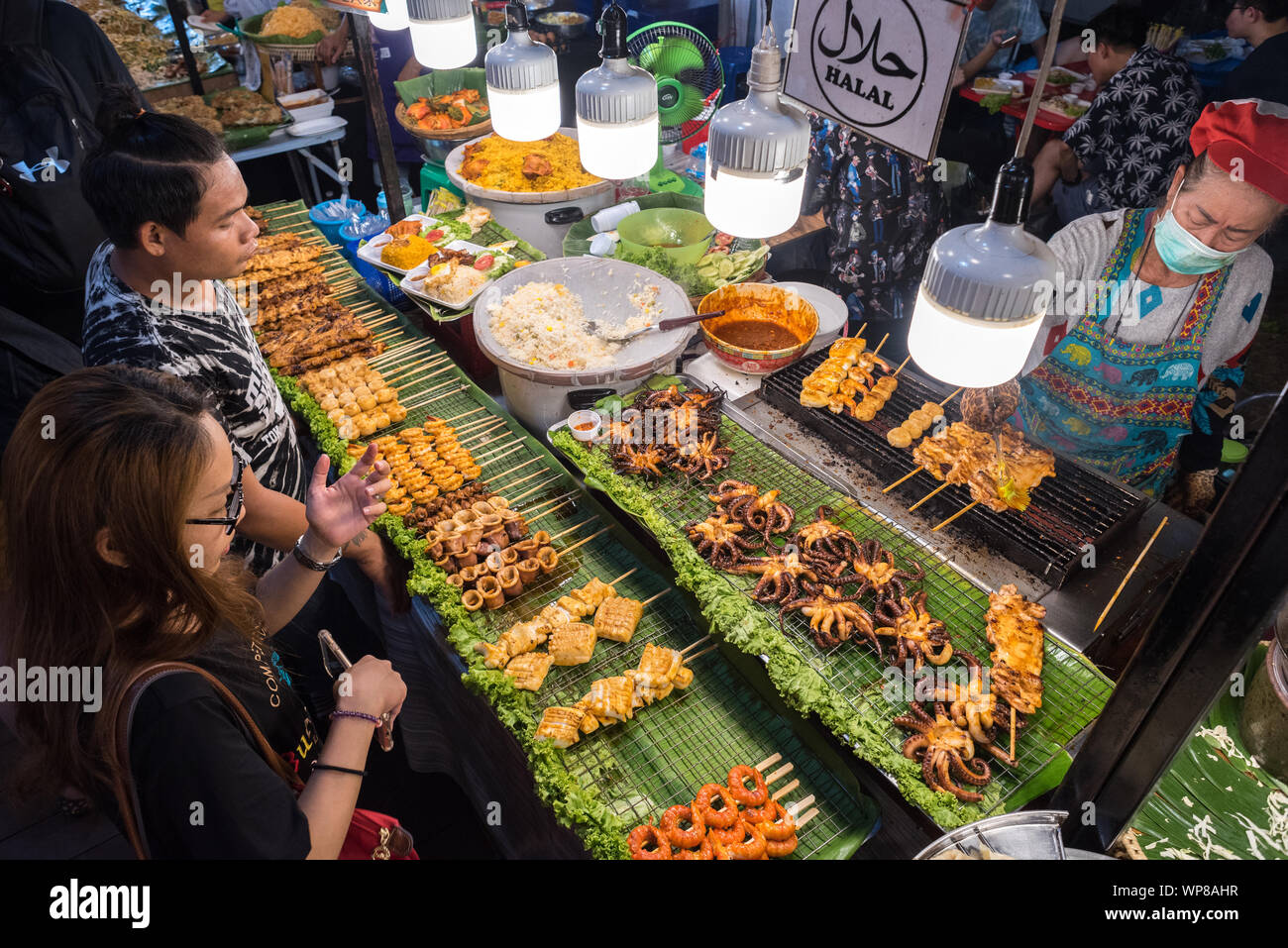 Bangkok, Tailandia - 28 Luglio 2019: uno stallo con pesce alla griglia a Asiatique il Riverfront street market alimentare durante la notte. Foto Stock