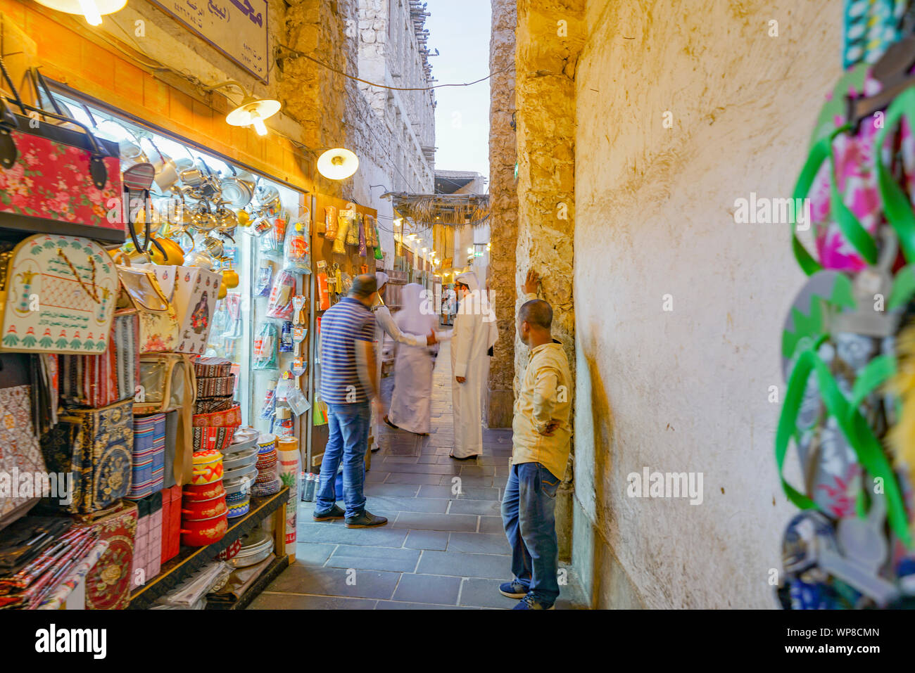 DOHA IN QATAR - 11 luglio 2019; concentrarsi sull uomo arabo nel consueto vesti bianche in corsia tra i fornitori del mercato e dei prodotti e l'atmosfera di Souq Waqif Foto Stock