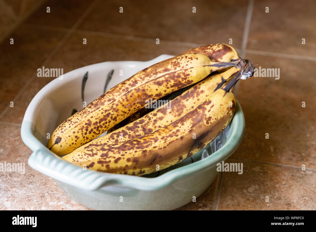 Ciotola di banane mature sul banco di cucina Foto Stock