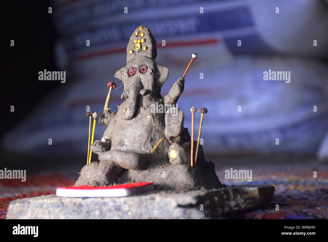 Signore Ganesha nel fuoco selettivo, costituito da argilla con colorati blur sullo sfondo, in un villaggio indiano Foto Stock