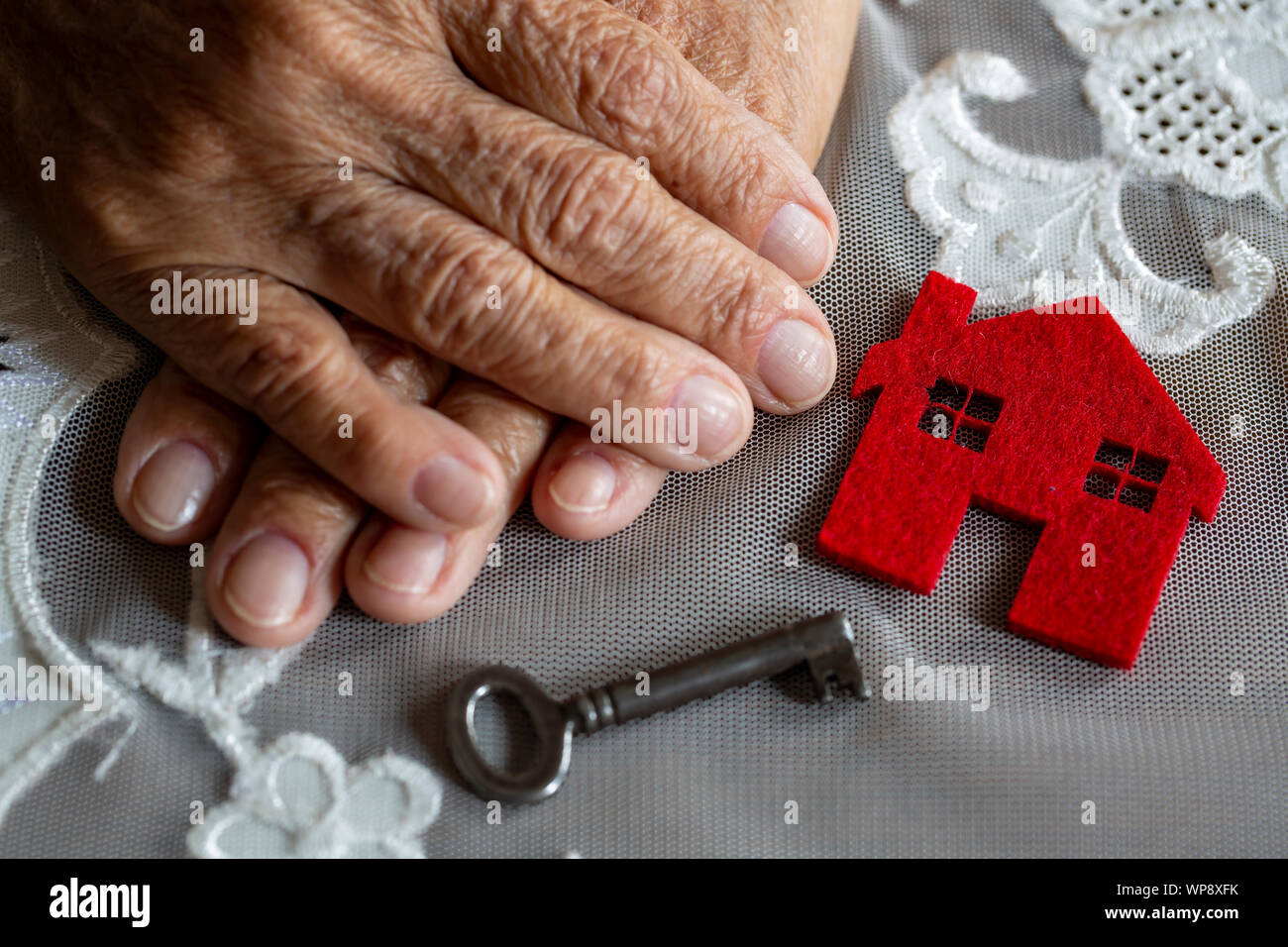 Vecchia donna mano con house e chiave Foto Stock