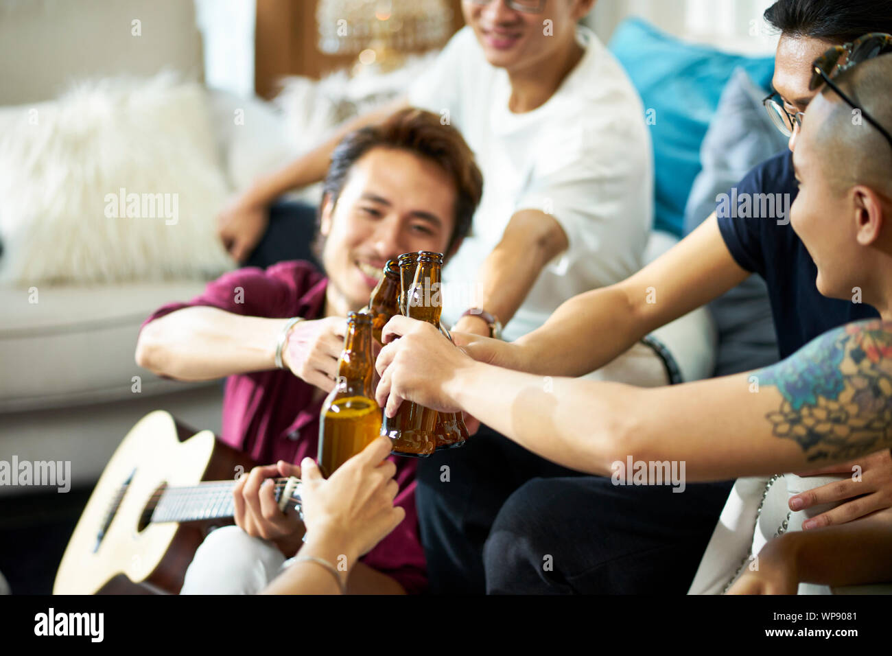 Giovani asiatici uomini adulti bere birra a casa Foto Stock