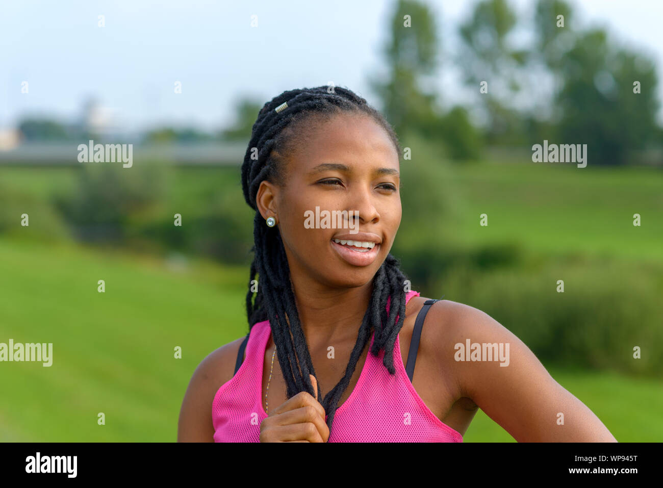 Considerato giovane donna africana intrecciata con le estensioni di capelli svolta a guardare la fotocamera Foto Stock