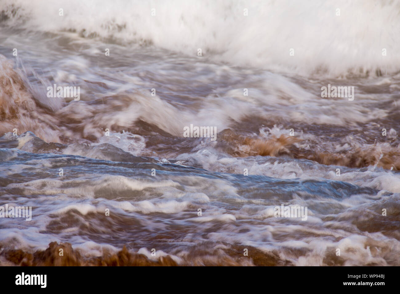 Pomeriggio Un forte marea marea con le onde che si infrangono sulle rocce sulle rocce con forti onde schiumose, una risacca, un lato wash. Reale onde arrabbiato. Foto Stock