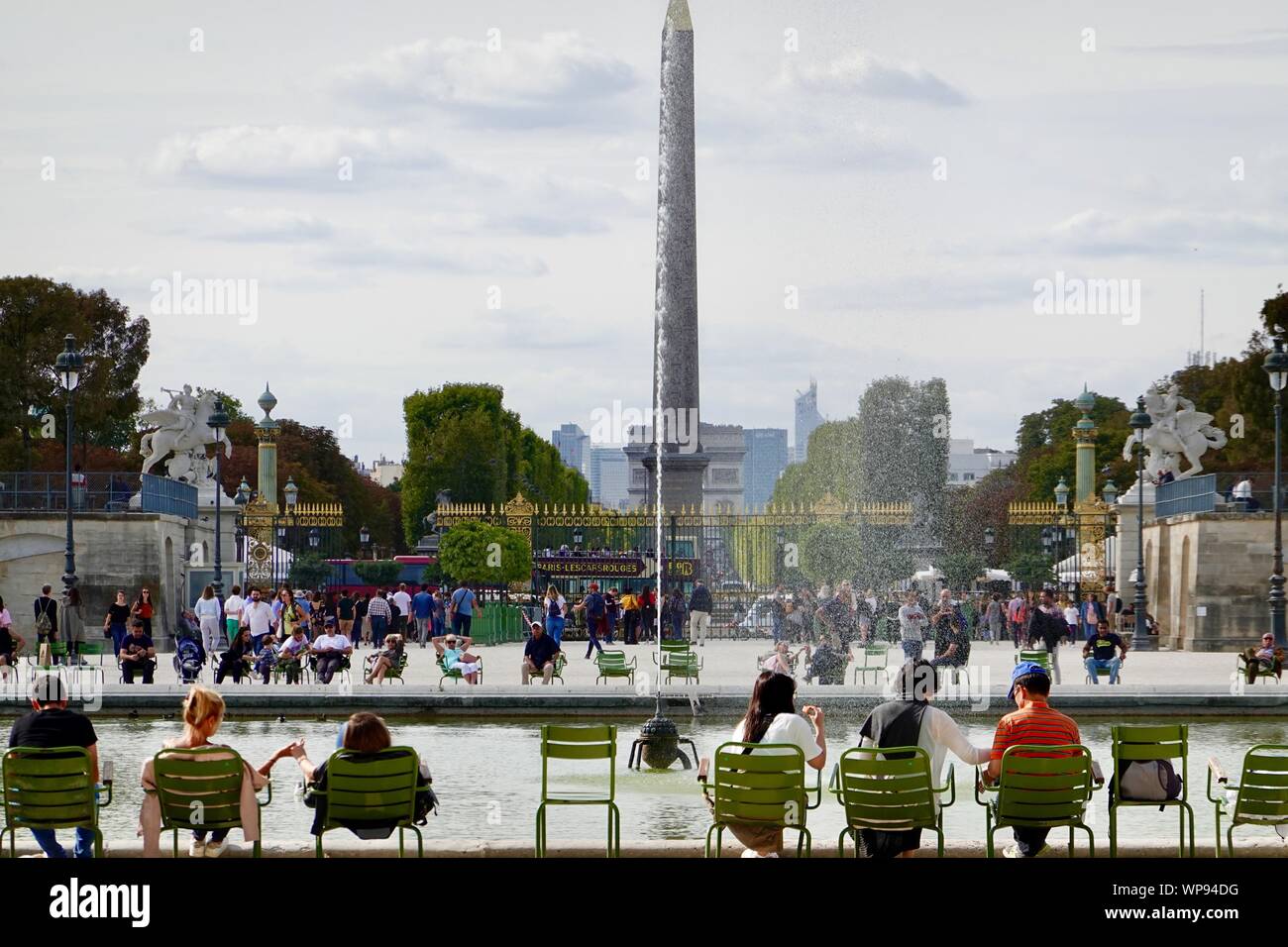 Persone sedute in sedie verde intorno al bacino ottagonale all'estremità  occidentale dei Giardini Tuileries, l'obelisco egizio nel posteriore,  Paris, Francia Foto stock - Alamy