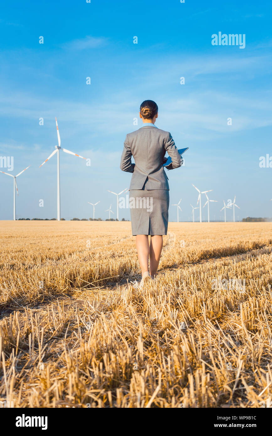 Un investitore in energia verde guardando il suo turbine eoliche Foto Stock