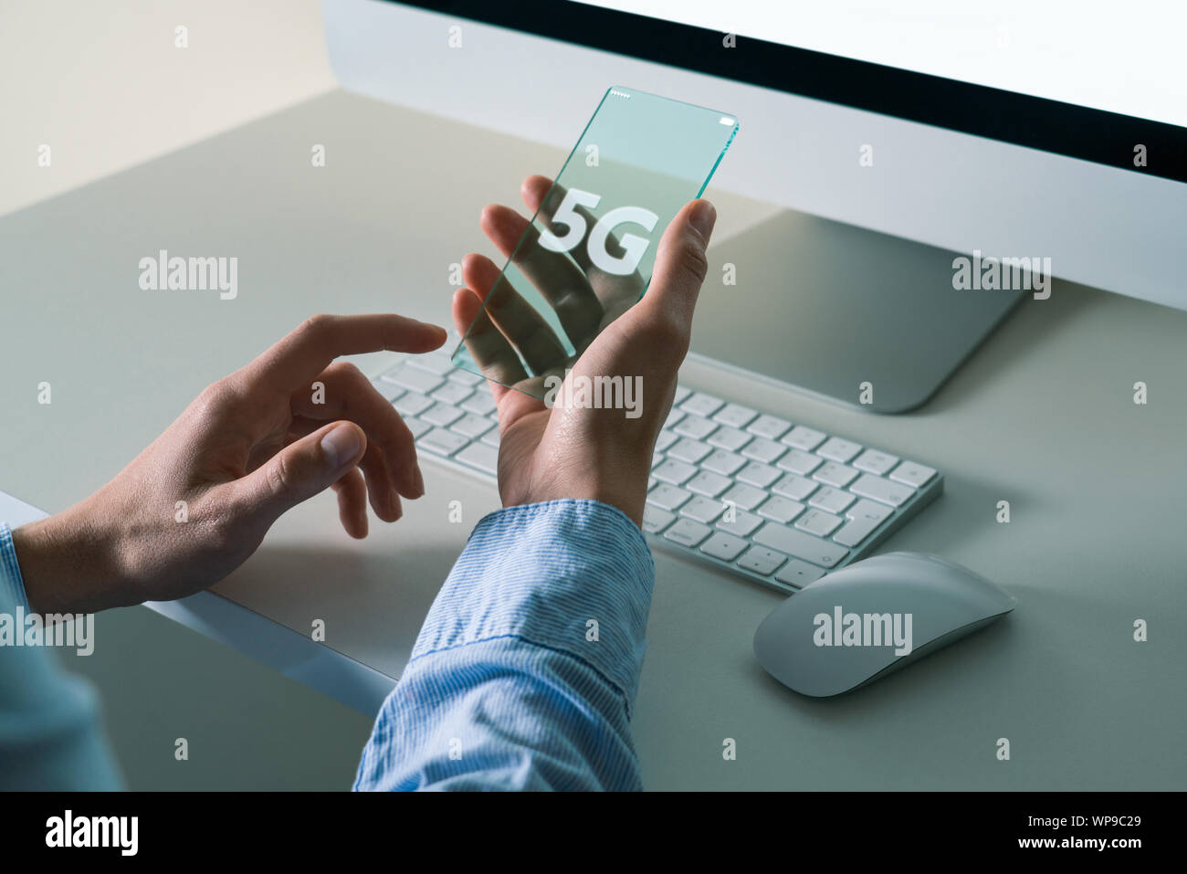 Un uomo utilizza un avveniristico telefono trasparente con 5G Foto Stock