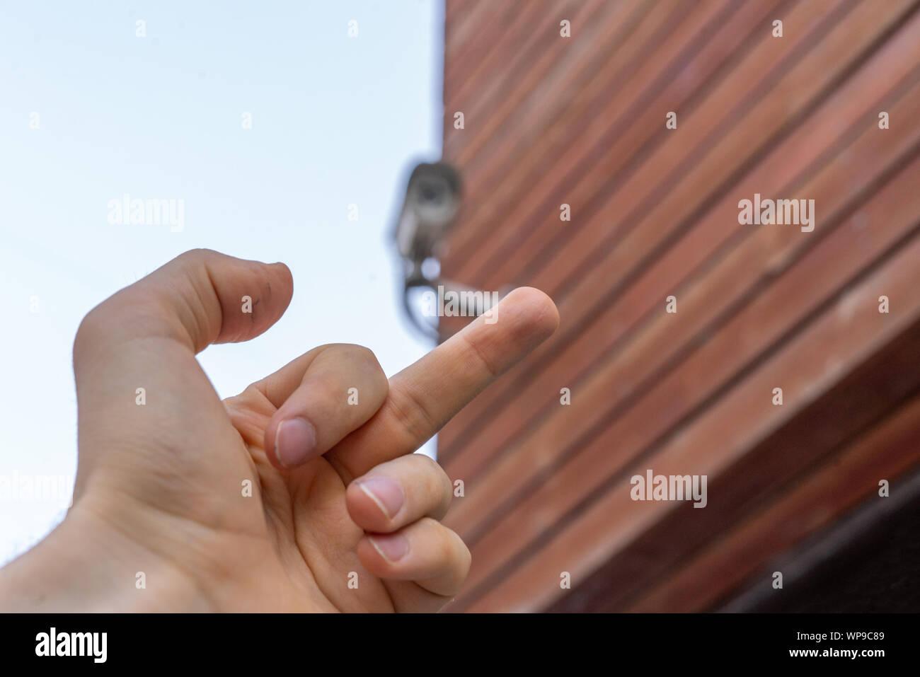Fpv mano mostra il dito medio per telecamera TVCC in pubblico per le strade delle città Foto Stock
