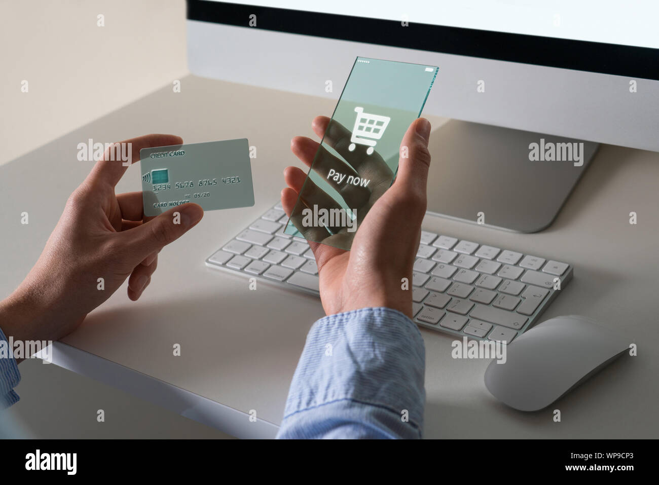 L'uomo utilizza un avveniristico telefono trasparente e una carta di credito per il pagamento on-line Foto Stock