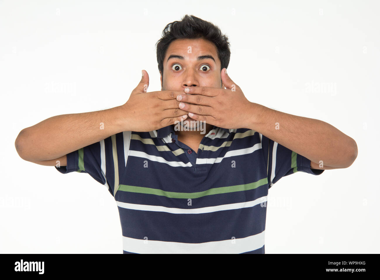 Sorpreso giovane uomo che copre la sua bocca Foto Stock