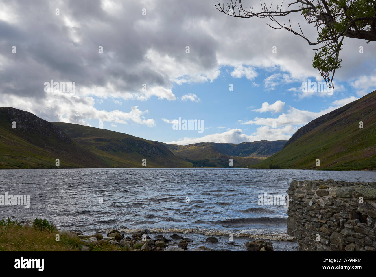 Loch Lee, ora un serbatoio in corrispondenza della testa di Glen Esk in Cairngorm National Park in una giornata di vento in settembre, con le nuvole scudding attraverso il cielo blu Foto Stock