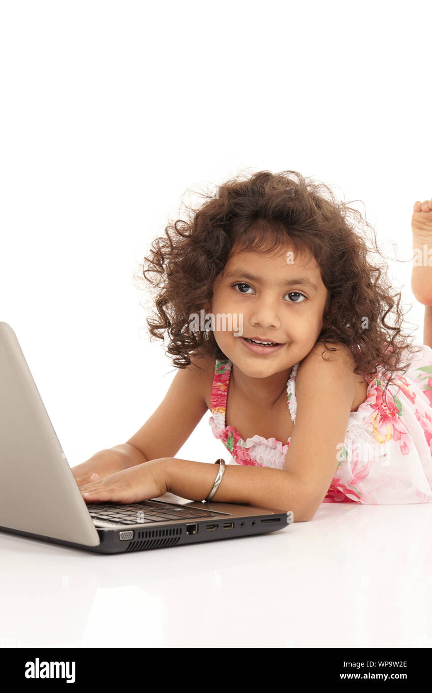 Girl lying on floor and using a laptop Foto Stock