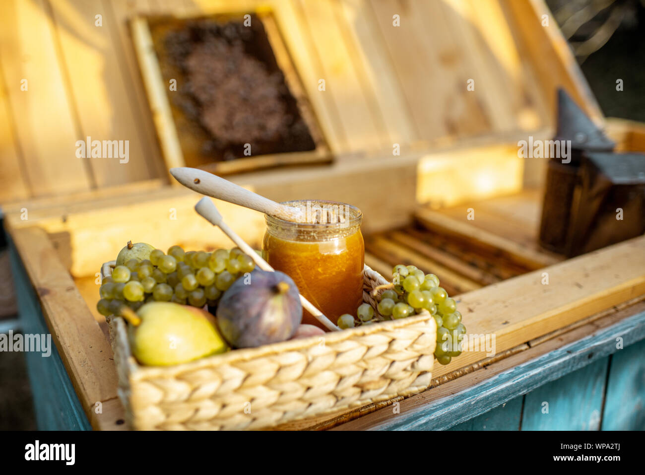 Composizione di frutti dolci e jar con del miele per alveare con il nido d'ape sullo sfondo Foto Stock