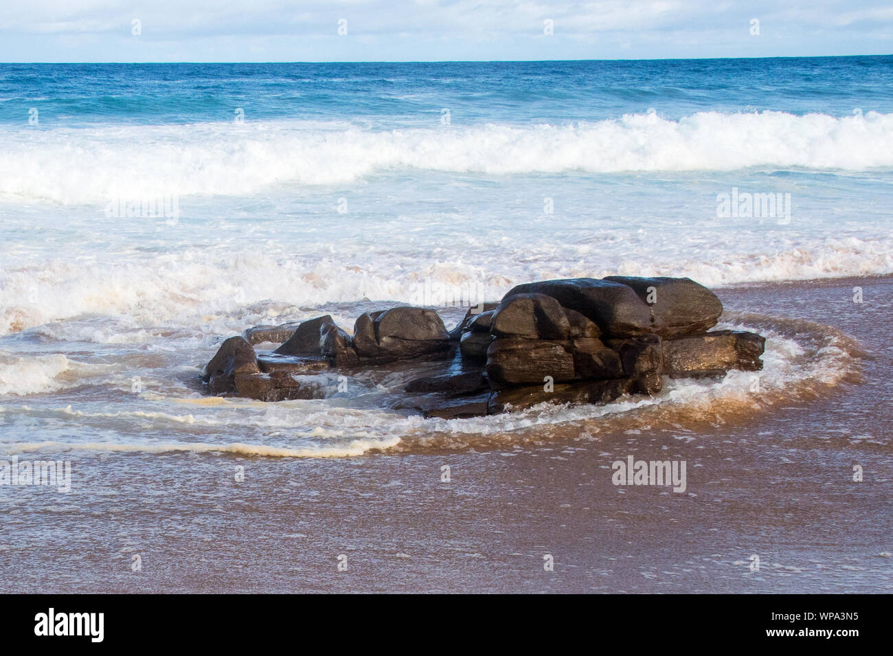 Incantevoli paesaggi marini con acque blu, e le onde si infrangono contro una roccia come onde crash nel tardo pomeriggio. Vi è un clima sereno e frescura. Foto Stock