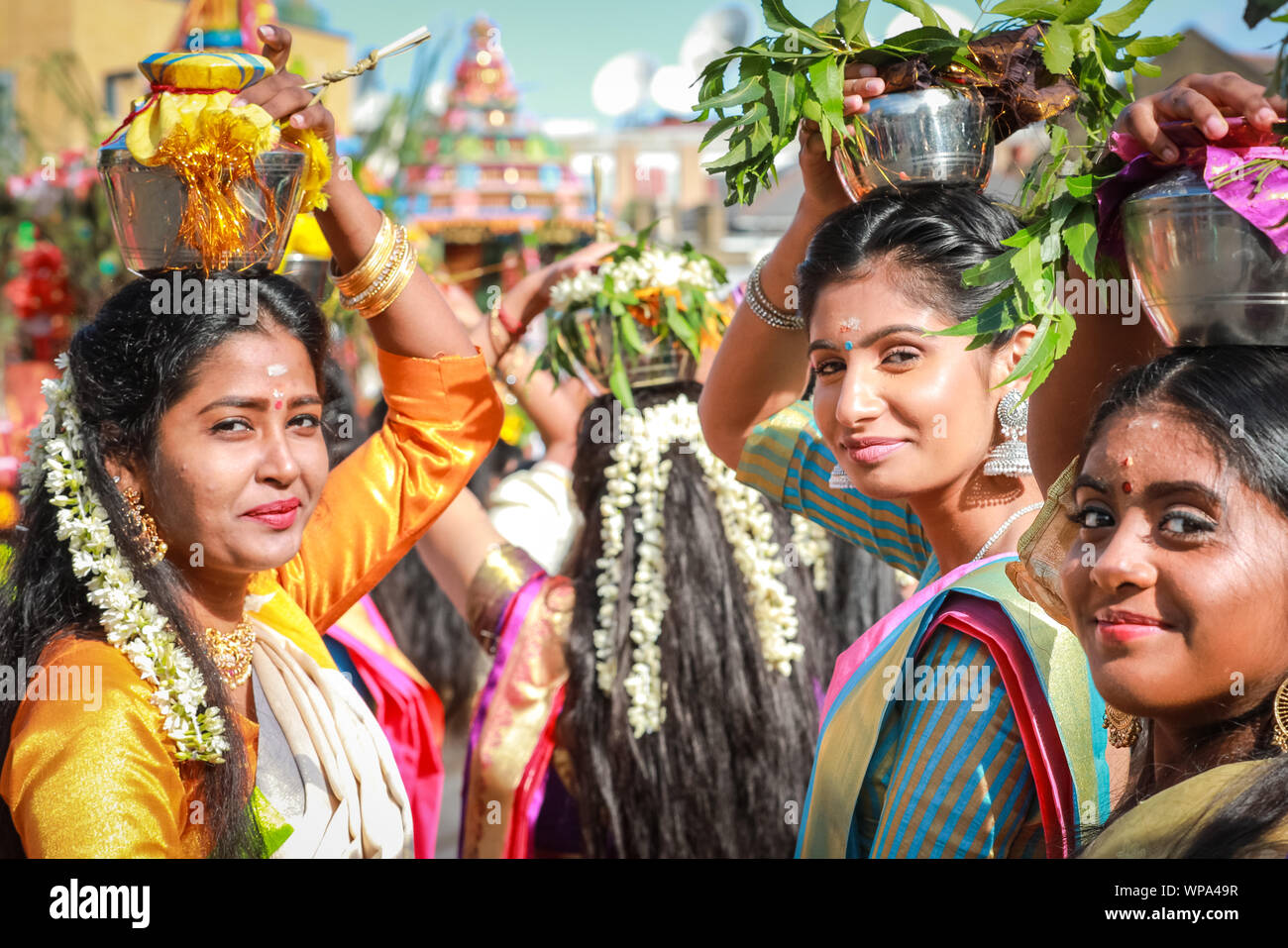 Lewisham, Londra, Regno Unito. 8 settembre 2019. Molte donne tengono in mano vasi di argilla incenso bruciati o vasi pieni di latte sulla testa come offerte agli dei. I fedeli celebrano l'annuale Tamil Chariot Festival (ther) con una processione. I visitatori si mescolano con i partecipanti mentre la colorata processione si snoda attraverso il sobborgo di Londra dal Tempio Sivan Kovil di Londra. Crediti: Imageplotter/Alamy Live News Foto Stock