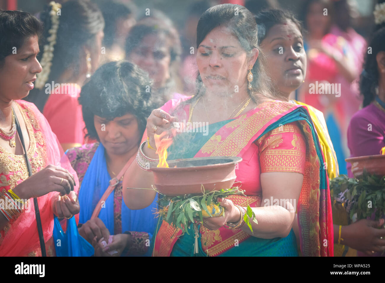 Lewisham, Londra, Regno Unito. 8 settembre 2019. Molte donne tengono in mano vasi di argilla incenso bruciati o vasi pieni di latte sulla testa come offerte agli dei. I fedeli celebrano l'annuale Tamil Chariot Festival (ther) con una processione. I visitatori si mescolano con i partecipanti mentre la colorata processione si snoda attraverso il sobborgo di Londra dal Tempio Sivan Kovil di Londra. Crediti: Imageplotter/Alamy Live News Foto Stock