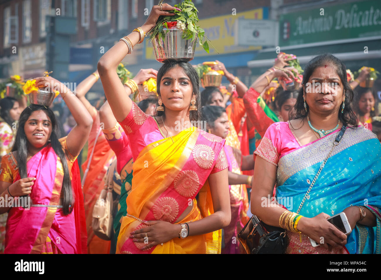 Lewisham, Londra, Regno Unito. 8 settembre 2019. Molte donne tengono in mano vasi di argilla incenso bruciati o vasi pieni di latte sulla testa come offerte agli dei. I fedeli celebrano l'annuale Tamil Chariot Festival (ther) con una processione. I visitatori si mescolano con i partecipanti mentre la colorata processione si snoda attraverso il sobborgo di Londra dal Tempio Sivan Kovil di Londra. Crediti: Imageplotter/Alamy Live News Foto Stock