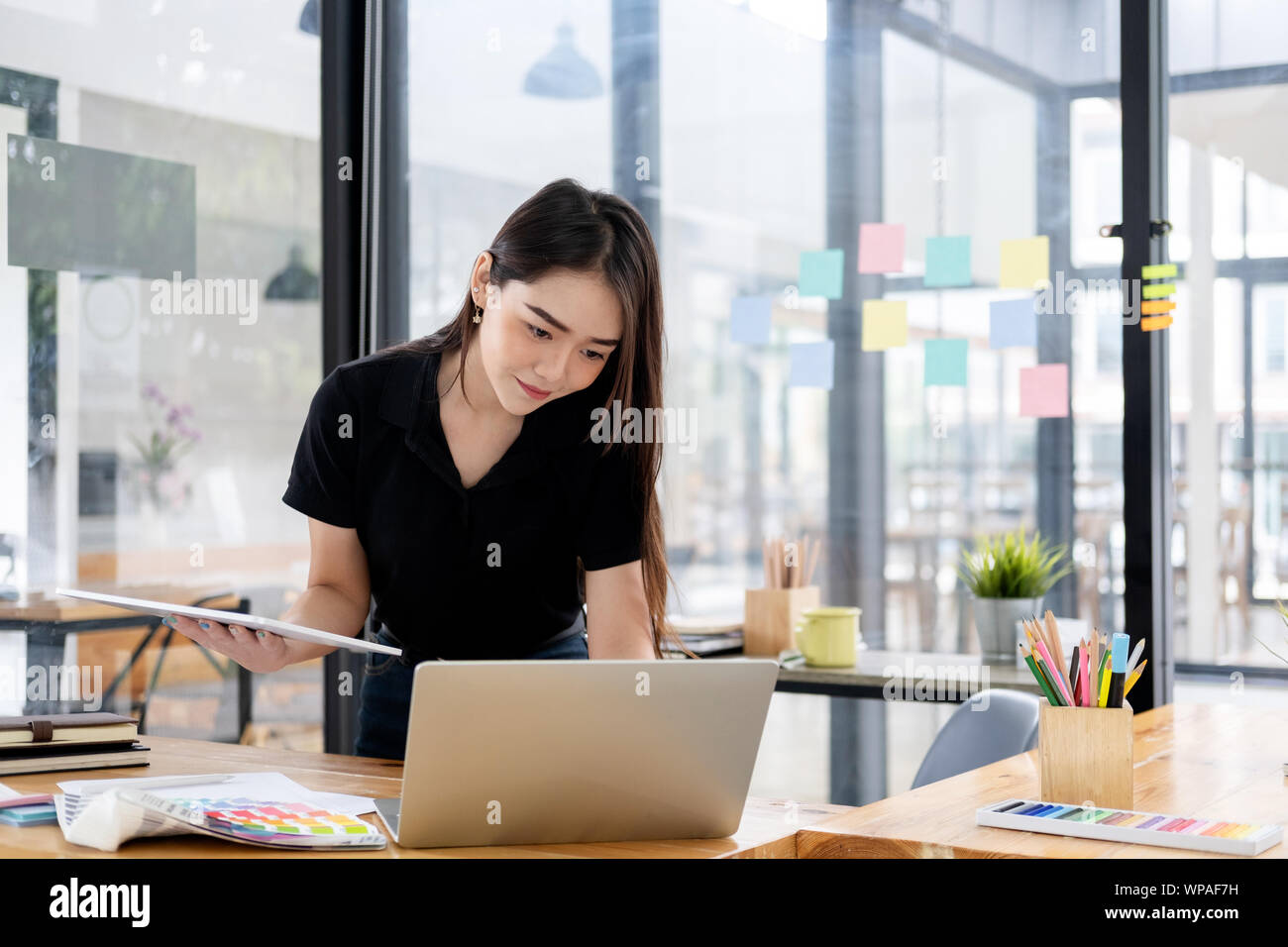 Graphic designer che lavora alla sua scrivania in creative studio ufficio. Foto Stock